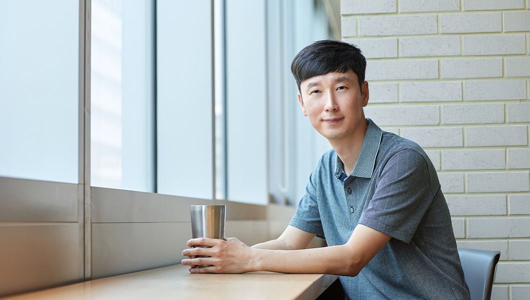 a man sitting at a table with a cup