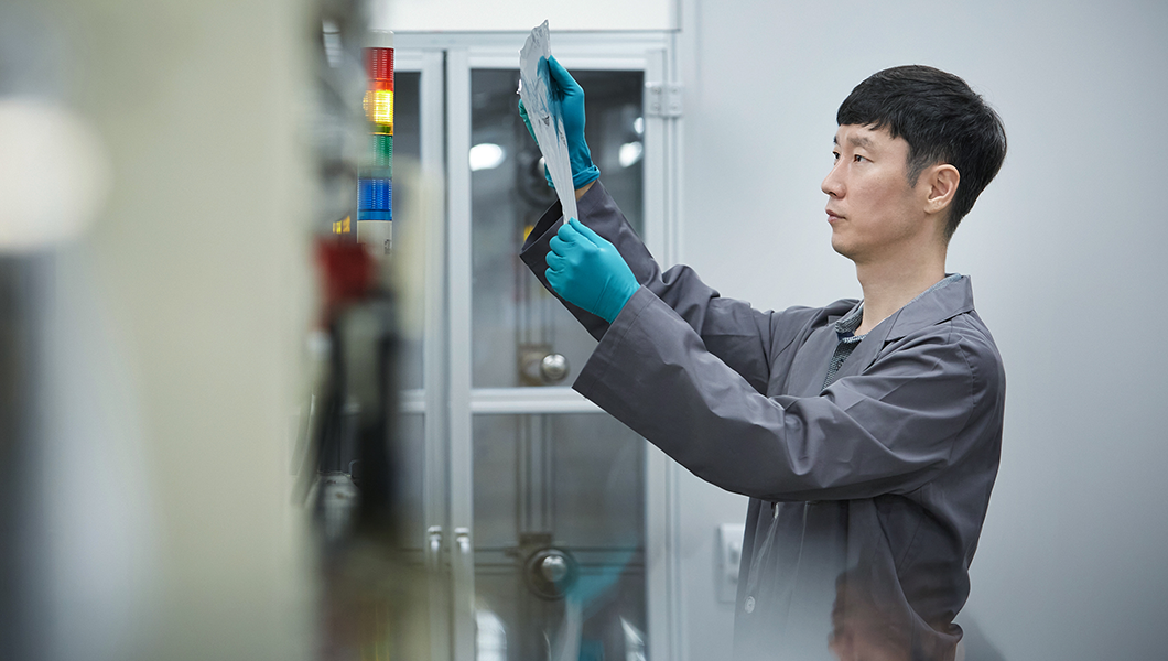 a man wearing gloves and holding a piece of paper