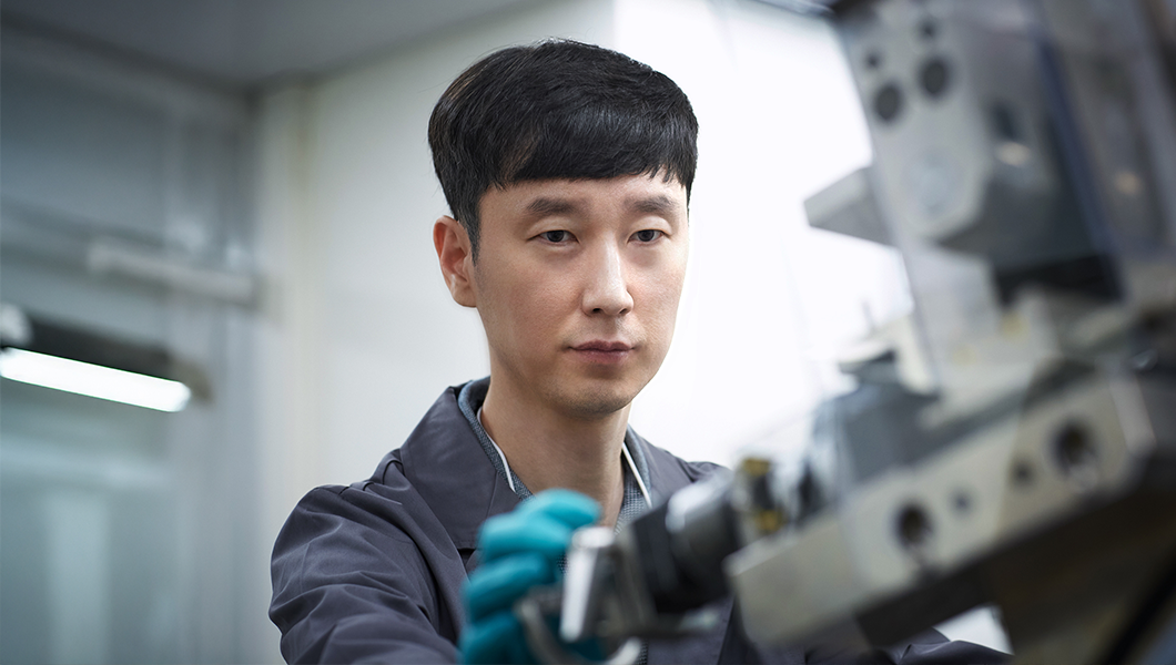 a man wearing gloves and holding a machine