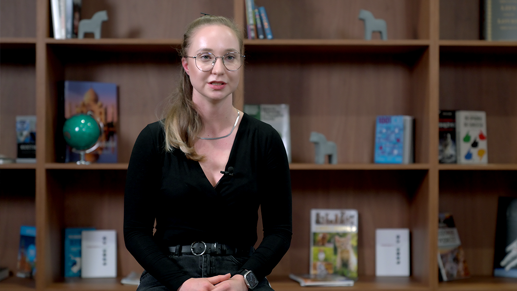 a woman sitting in front of a book shelf